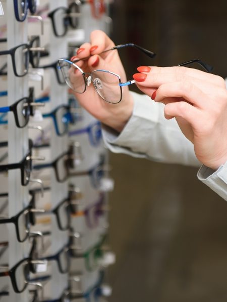 Closeup of optometrist, optician giving glasses to try